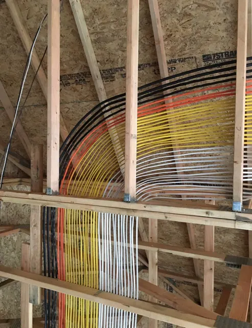 Colour-coded cable sweeping through roof trusses